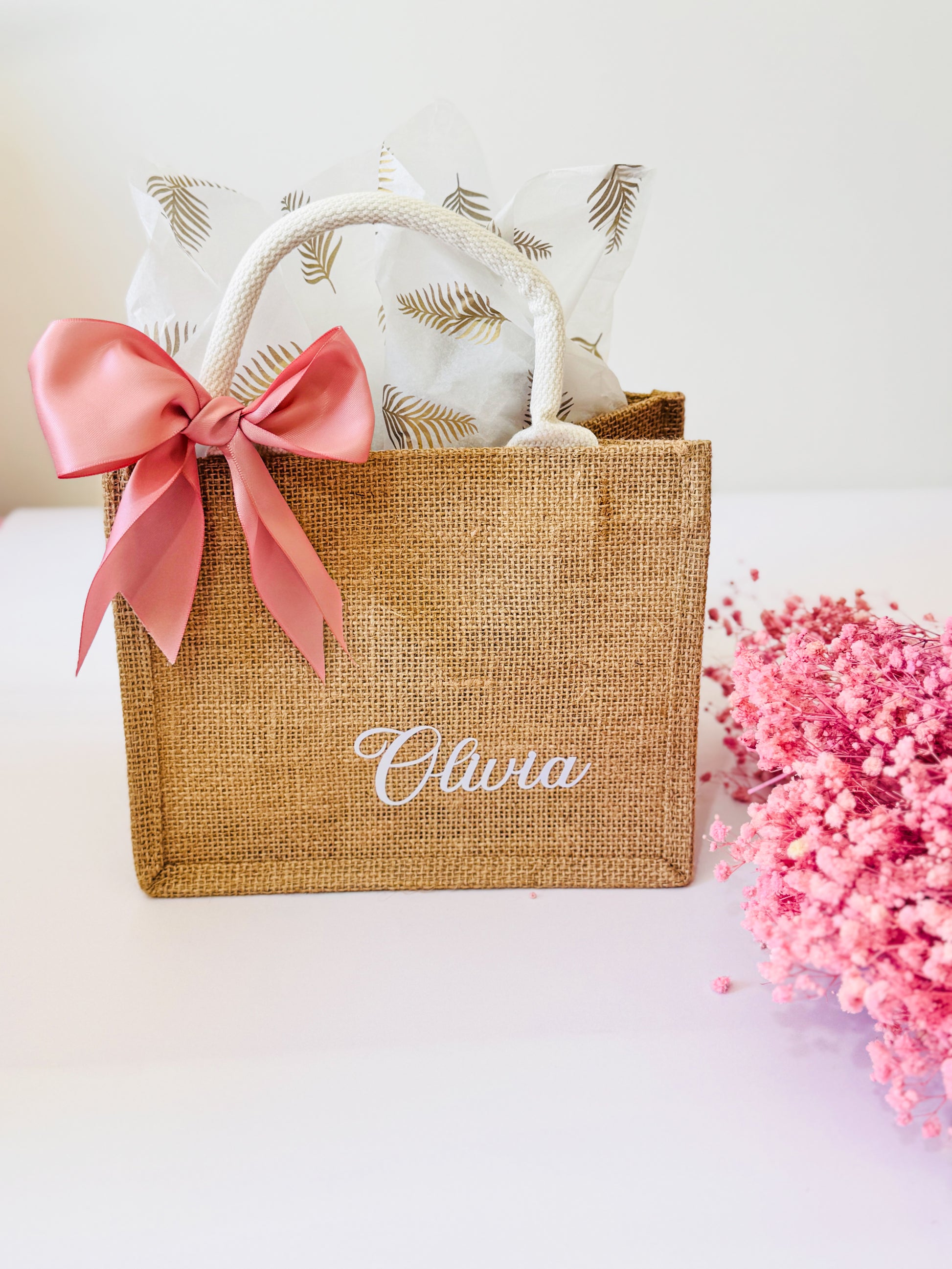 Jute bag with pink bow and 'Olivia' branding on a white background